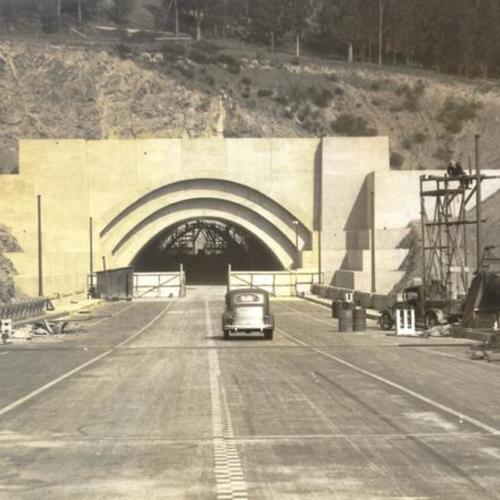 [View of automobiles heading into the nearly completed Yerba Buena Island tunnel during San Francisco-Bay Bridge construction]
