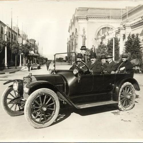 [Group of men in an automobile on the Avenue of Progress at the Panama-Pacific International Exposition]