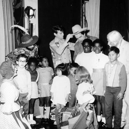 [Performers in costumes visiting with students at Redding School]