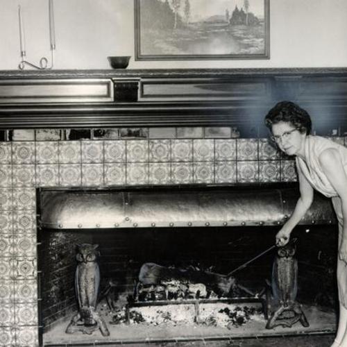 [Mrs. M. E. McIntyre standing before a tiled fireplace in the former Spreckels mansion]
