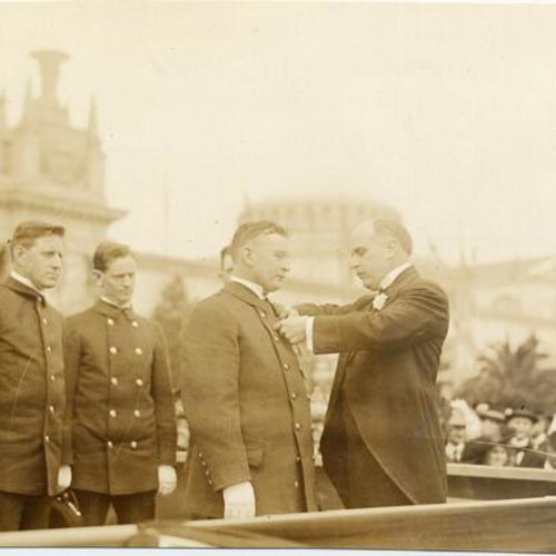 [Mayor James Rolph presenting medals to firemen at the Panama-Pacific International Exposition]
