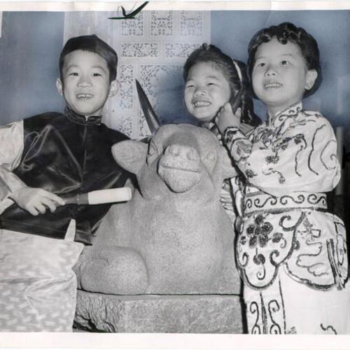 [Three children posing with the ox, the symbol of the new year]