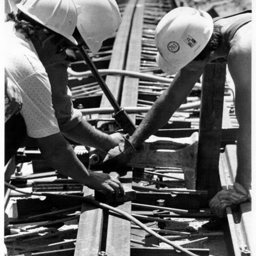[Workers setting a slot rail in place on a cable car track at Sacramento and Hyde streets]