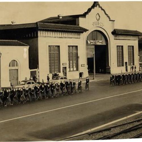[Soldiers marching past Pier 22]