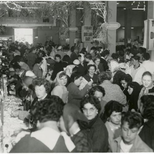 [Crowd of people inside a store on Mission Street for "Dollar Day"]