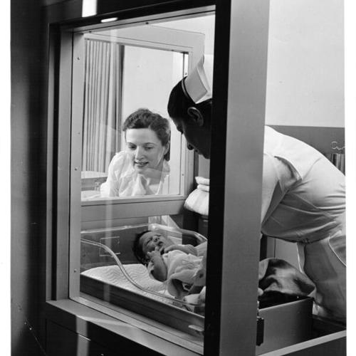 [Maternity patient views newborn in Kaiser Hospital nursery]