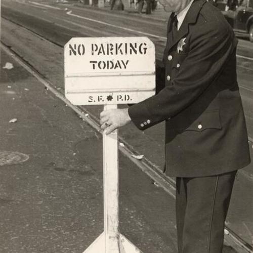 [Officer John Finn places a "No Parking" sign on Market Street]