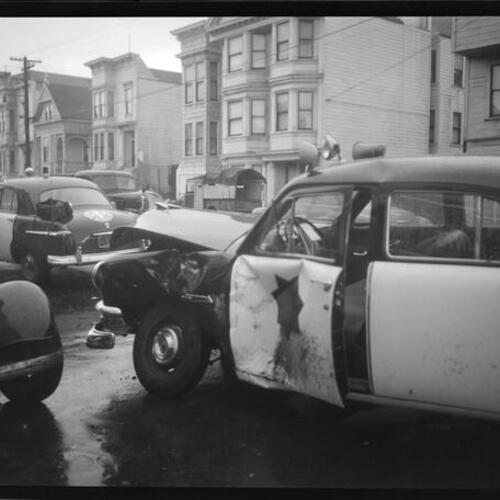 [Automobile collision at intersection of 24th and Harrison, side view of damaged Police car]