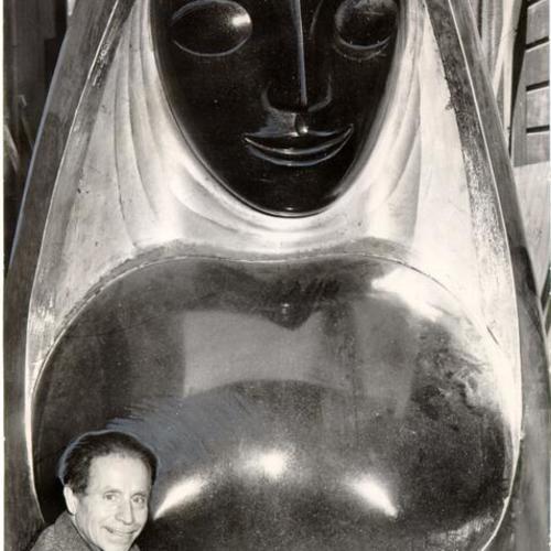 [Artist Beniamino Bufano posing with his sculpture titled "Peace"]
