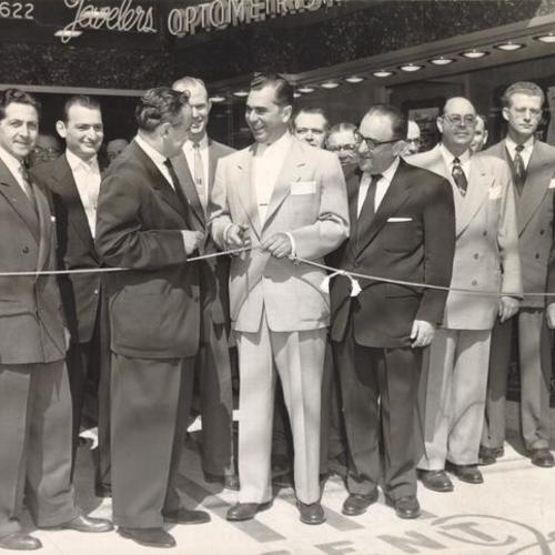 [San Francisco Supervisor Marvin Lewis cutting the ribbon at an opening ceremony for the Crescent Jewelers store at 2622 Mission Street]