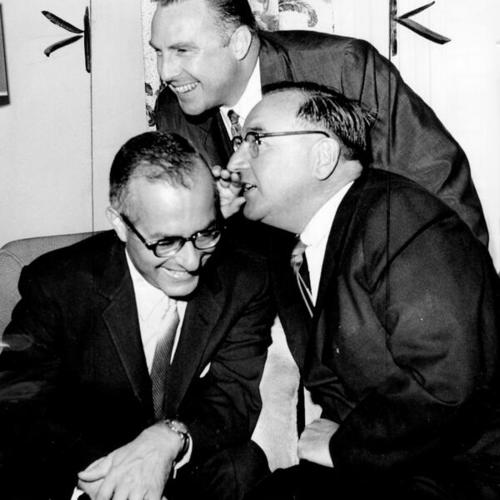 [Judge Stanley Mosk, Democratic candidate for attorney general, gets a whisper from Attorney General Edmund G. Brown, while Congressman Pat J. Hillings listens in]