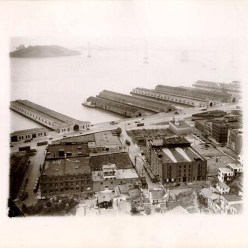 [View of the waterfront with the Bay Bridge under construction in the background]