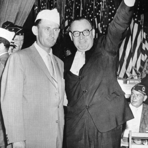 [Governor Pat Brown, right, acknowledge applause here today he is introduced by John Flynn, commander of the American Legion's California Department]