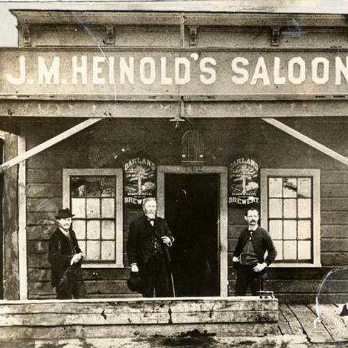 [George Gibson, Alfred Burrell and Jack Heinold standing in front of J. M. Heinold's saloon]