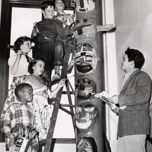 [Children from Excelsior School showing Martin Metal a 15 foot totem pole they designed as an art project]