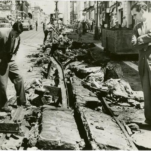 [Pedestrians inspecting the uprooted tracks of the Jones street cable car]