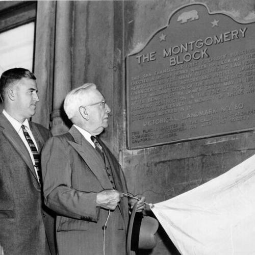 [Alex Arguello and Oliver Petry Stidger unveiling a plaque on the side of the Montgomery Block building]
