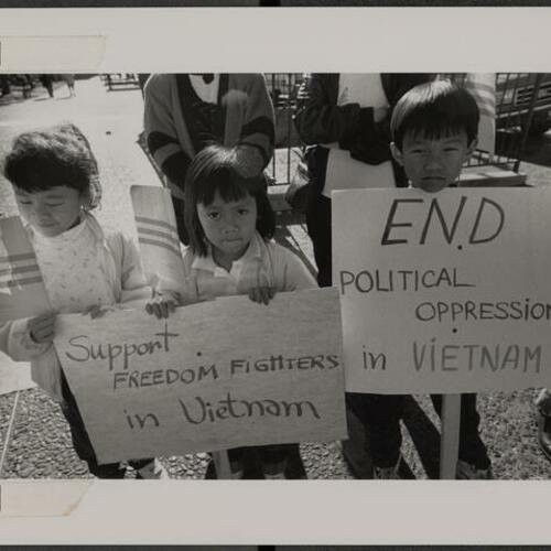 Vietnamese children holding signs outside City Hall protesting government oppression in Vietnam