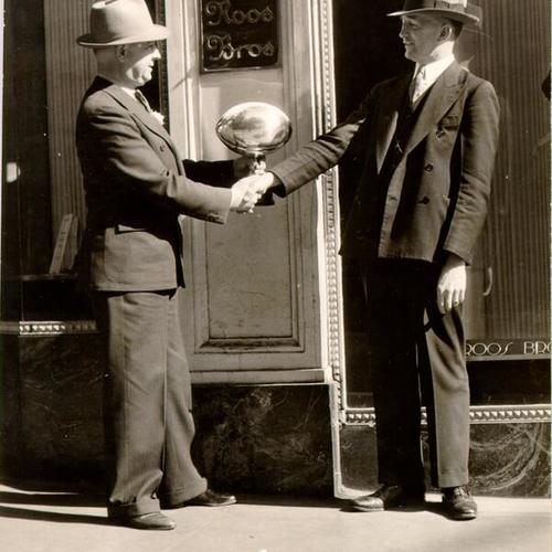 [L. N. Bourgehault and Dean Edwin Browne standing in front of a Roos Brothers store]