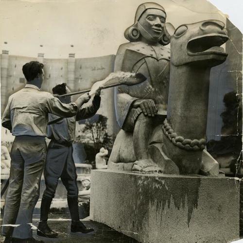 [Joe Walsh and Sven D. Lange cleaning Inca Indian and Llama sculpture by Sargent Johnson on Treasure Island]