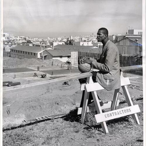 [Boston Celtics basketball player Bill Russell watching construction of gymnasium at the University of San Francisco]