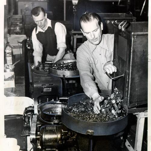 [Bob Oppenheim and Frank Smith operating coin counting machines at the U. S. Mint in San Francisco]