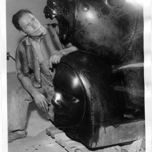 [Beniamino Bufano examines his statue of a California golden bear]