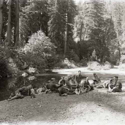People gather outside sitting near water at Camp McCoy