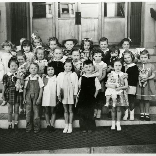 [Patrick Henry kindergarten class posing with dolls and books]