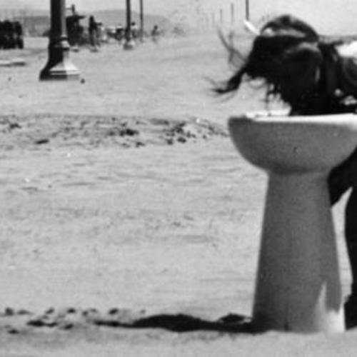 [Young girl drinking from a water fountain by the side of the Great Highway]