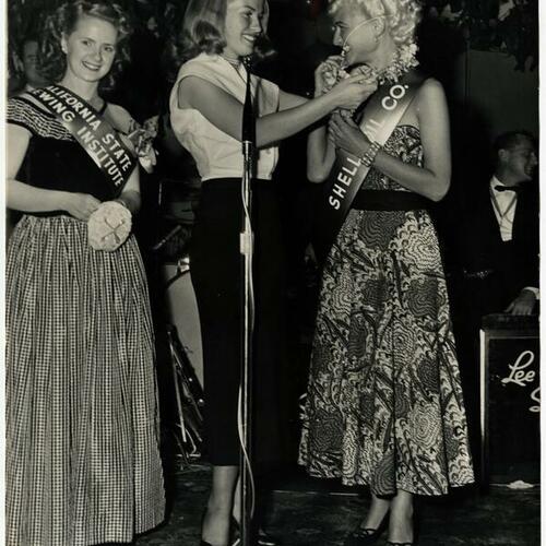 Cable Car Carnival runner up Patsy Stanley (left) with Miss San Francisco Patricia Anna Sheehan presenting Cable Car Queen Sylvia Baraff with orchard lei