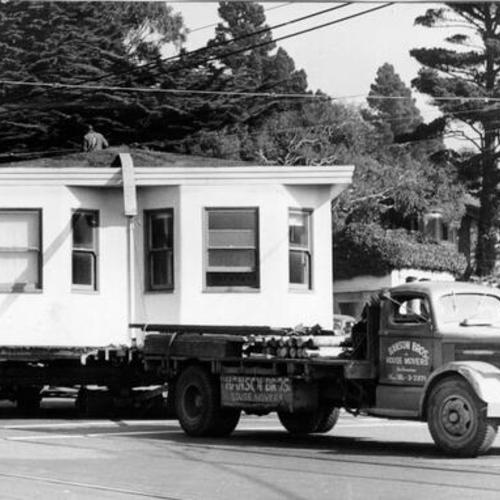 [Truck and trailer carrying away house to make way for a widening project on Portola Drive]