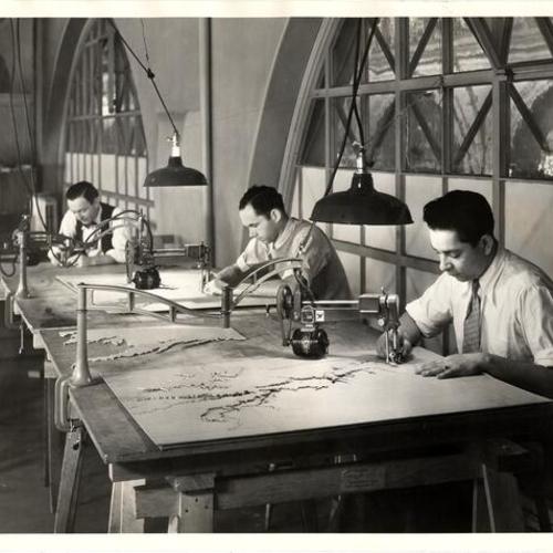 [SERA workers cutting the contour tracings for a map]