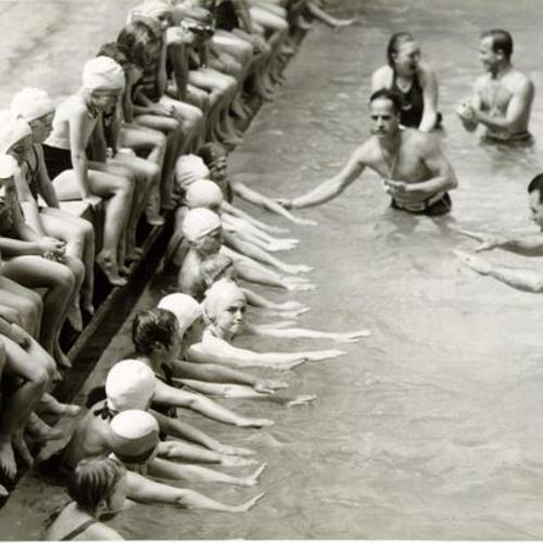[Group of women getting swimming lessons at Sutro Baths]