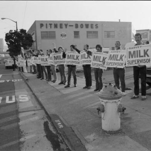 "Human Billboard" People standing on sidewalk with Harvey Milk Supervisor signs at Market Street near Duboce Avenue