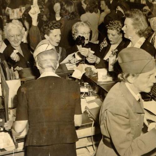 [Crowd of shoppers purchasing U. S. War Bonds and Stamps at the White House department store]