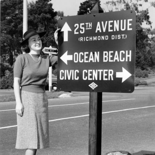 [Marjorie Mitchell standing next to a newly installed road sign in Golden Gate Park]