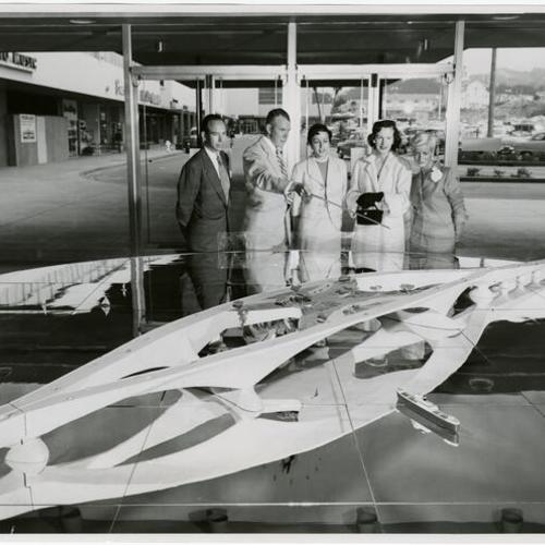 [Aaron Green, Arthur Hoggard, Mrs. Donald Magning, Mary Lee Futernick and Carole Weingarten being photographed with model of proposed "Butterfly Bridge" designed by Frank Lloyd Wright]