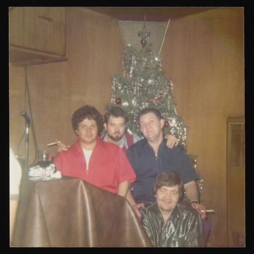 Portrait of four people in front of Christmas tree at Christmas party