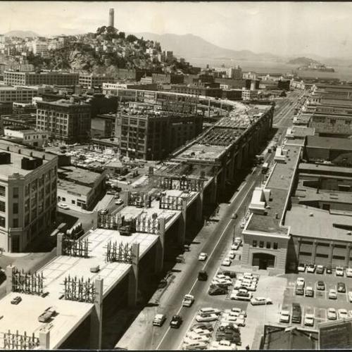 [Embarcadero Freeway under construction with Coit Tower in the background]