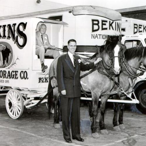 [Milo W. Bekins holding the reins of an old moving van stands next to Daniel P. Bryant the new president of Bekins Van and Storage]