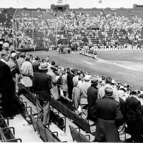 [Audience and players standing at beginning of opening day game between San Francisco Seals and Vancouver team in 1956]