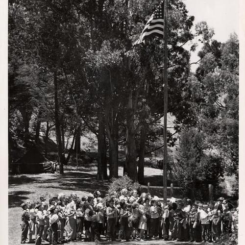 [Group of children pledging allegiance to the United States flag in the playground of Glen Park]