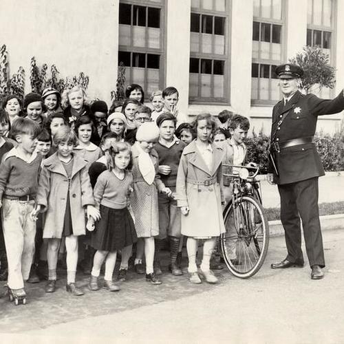 [Officer Chas Turner assisting youngsters crossing the street]