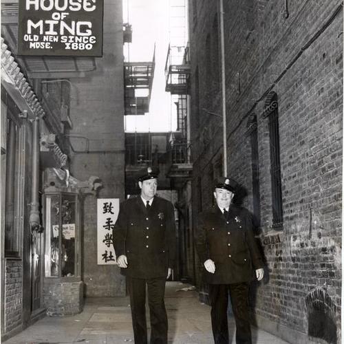 [Police officers Edward Nevin and James B. Dowd walking down Pelton Place in Chinatown]