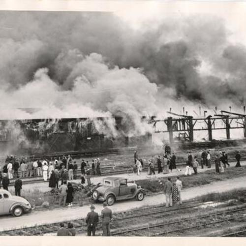 [Spectators in front of a freight transfer shed fire on 3rd Street]
