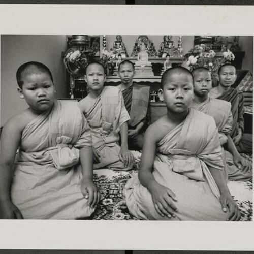 Four Cambodian children rekindle rite of passage tradition of Buddhist monkhood with elder monks sitting behind them