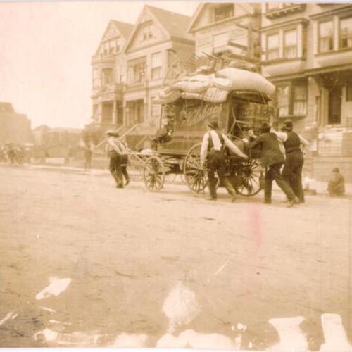 [Group of refugees pushing a carriage with their possessions]
