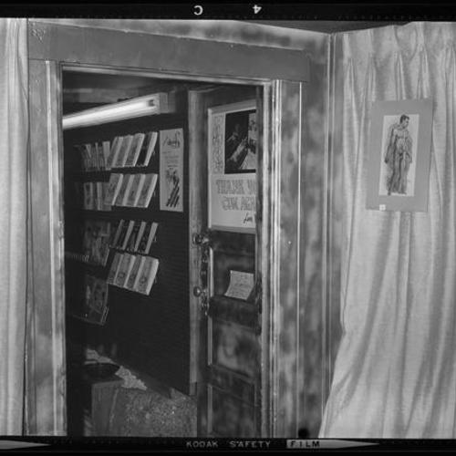 Interior view of doorway with reading rack, drawings, and signs on door, curtains, and walls