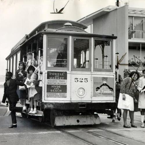 [Members of the Community Music Center Chorus getting off a cable car on Hyde Street]